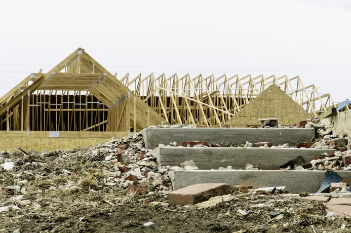 Contrast in tornado recovery Foreground of abandonment with broken debris by concrete steps of blasted foundation in contrast with reconstruction of single-family house across the street.jpeg